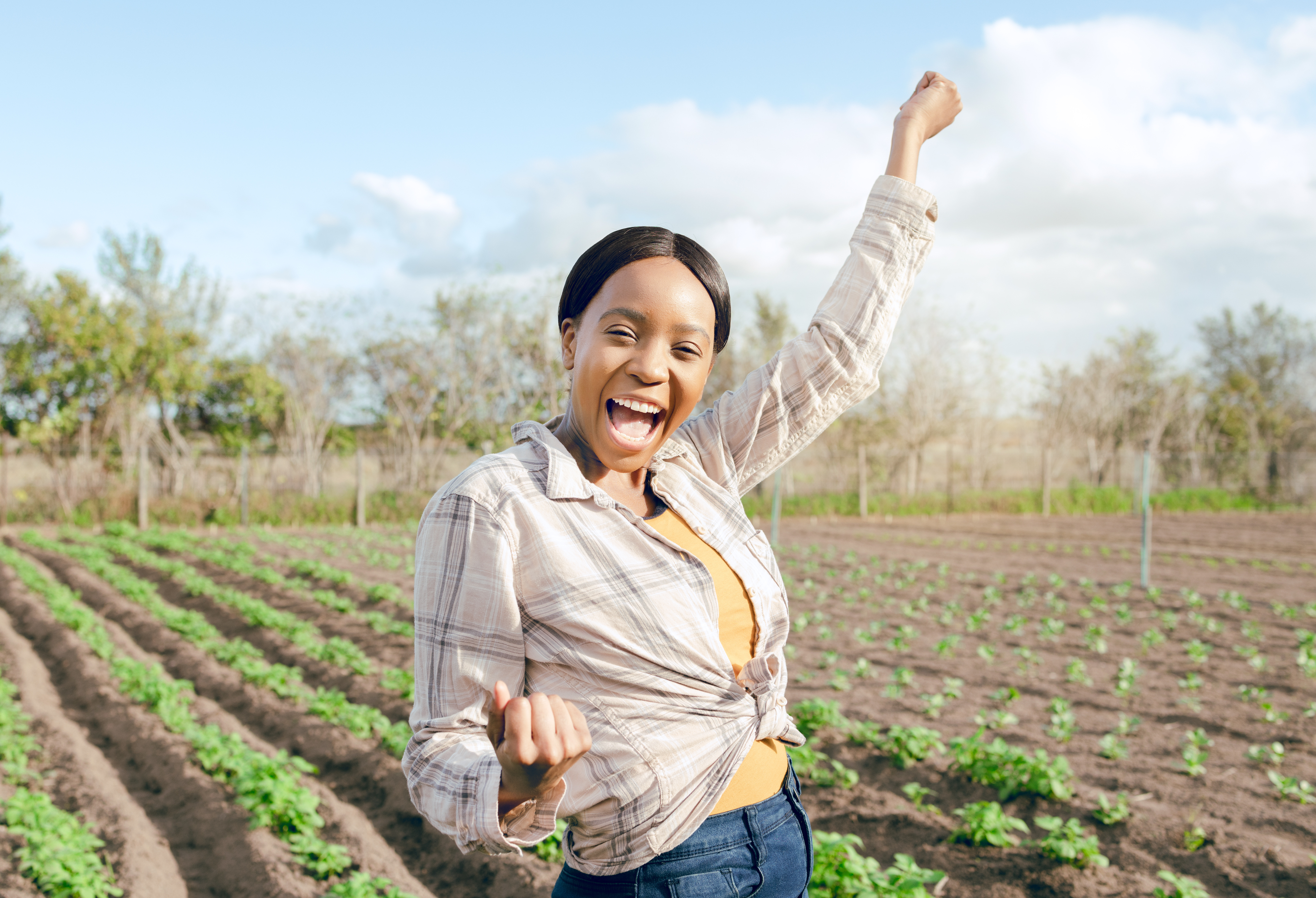 younger lighter skinned woman raising arms in excitement